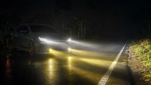 Mobil dengan lampu tambahan terarah di jalan minim penerangan pada malam hari